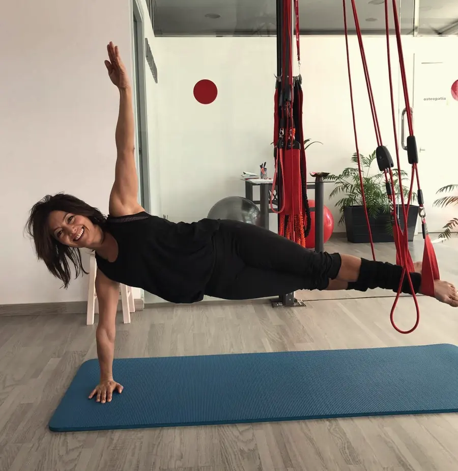 La Diana, fundadora de CordPilates, somrient mentre fa una planxa lateral amb RedCord