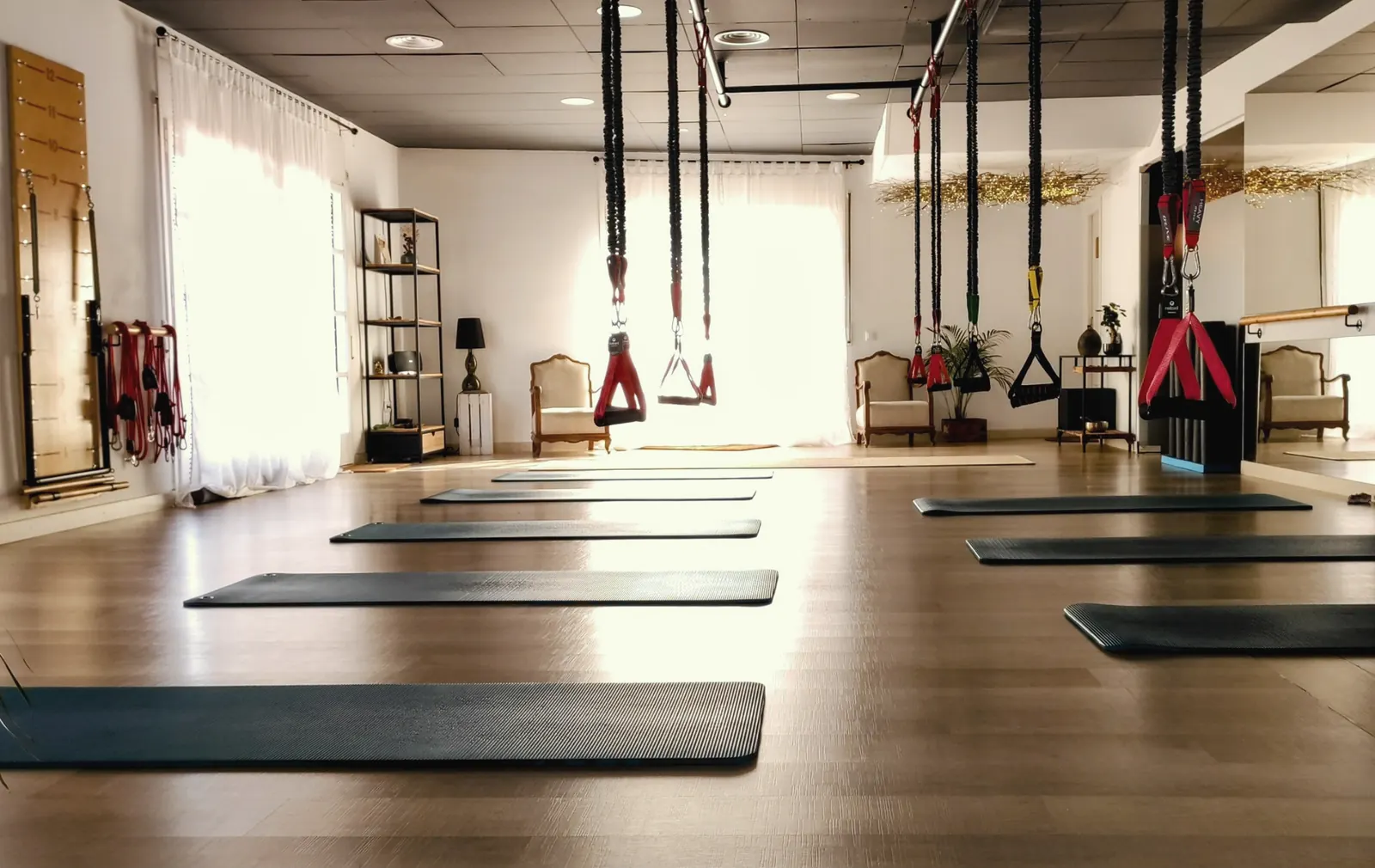 La sala de CordPilates amb llum natural, cordes de RedCord penjades del sostre i estores a terra